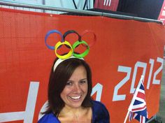 a woman holding a flag and olympic rings on her head