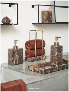 towels and soap dispensers on a marble countertop in a modern bathroom