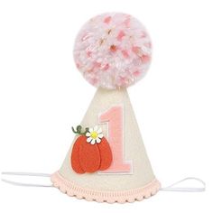 a birthday hat with a flower and number one on it's top, decorated with pom - poms