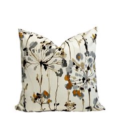 a white pillow with black and orange flowers on it