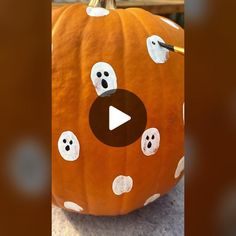 a pumpkin with ghost faces painted on it