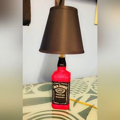 a lamp that is sitting on top of a table next to a bottle with a label on it