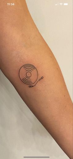 a person's arm with a tattoo on it that has a record player in the middle