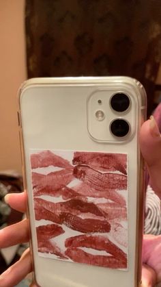 someone is holding up their phone case with lipstick prints on it