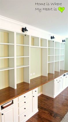 an empty room with white bookcases and wood flooring on the walls, along with hardwood floors