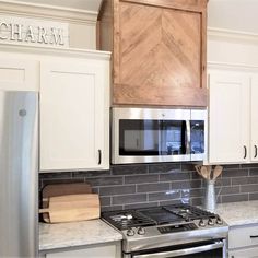 a stainless steel stove top oven sitting inside of a kitchen next to white cupboards