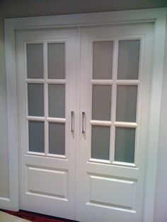 two white double doors with frosted glass on the front and side panels, in a room