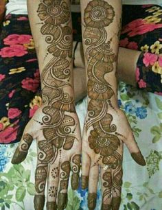 two hands with henna tattoos on them