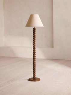 a lamp that is on top of a wooden table next to a wall and floor