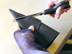 a person cutting paper with scissors on top of a table