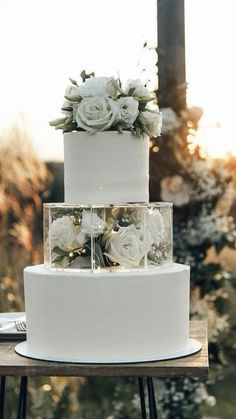 a three tiered cake with white flowers on top