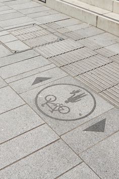 an arrow pointing to the right on a sidewalk with a bicycle sign in it's center