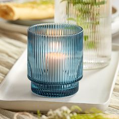 a blue glass candle holder sitting on top of a white tray