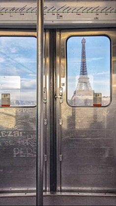 the door to an empty subway car with the eiffel tower in the background