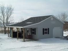 a small house with a covered porch in the snow