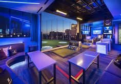 a living room filled with lots of furniture next to a window covered in blue lights