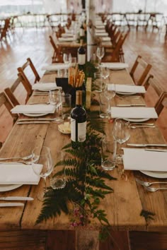 the table is set with place settings and wine bottles