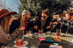 a group of people sitting around a table with drinks and condiments on it