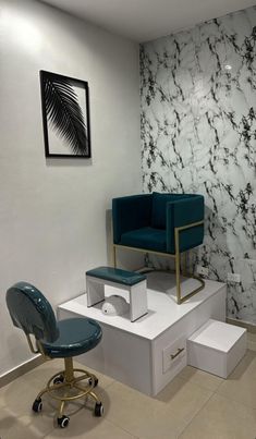 a chair and foot stool sitting in front of a wall with marbled paper on it