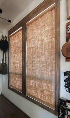 a large window covered in brown blinds next to a wall with other items on it