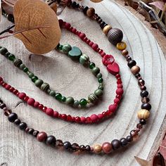 Beaded necklaces with an autumnal vibe! This set of designs feature a quirky asymmetric look, feature beads that sit on one side only. Fun and fabulous :) Not your average beaded necklace, these designs consist of a multitude of beads, in varying sizes, shapes and complimentary tones. I use wood, glass, ceramic, stone and gemstone beads in my necklaces, each design will feature a variety of these.  Green: A wooden heart nestles between two ceramic pumpkin beads. Red: Wonderful wine red tones, wi Pumpkin Bead, Wood Bead Necklace, Wooden Hearts, Beaded Flowers, Wood Beads, Long Necklace, Gemstone Beads, Necklace Etsy, Halloween Shopping