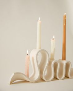 three candles are placed in the shape of swans and one is shaped like a swan