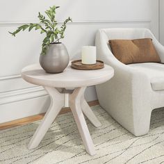 a living room with a chair, table and potted plant on the floor next to it