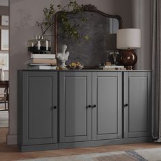 a grey sideboard with drawers and a mirror above it in a room that has a rug on the floor