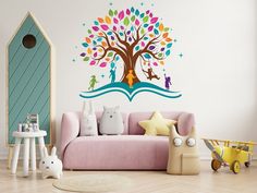 a child's room with a pink couch and colorful tree wall decal