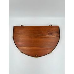 a wooden plaque mounted to the side of a wall with brass trimmings on it