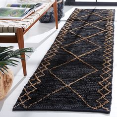 a black and tan rug sitting on top of a floor next to a wooden table