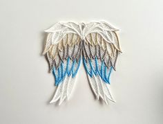 two white and blue angel wings on a white surface