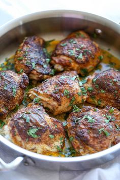 a pan filled with meat covered in herbs