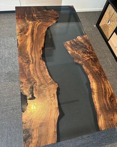 a table made out of wood and glass with water running down the side, on top of carpeted flooring