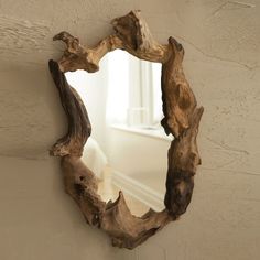 a mirror made out of driftwood on the wall