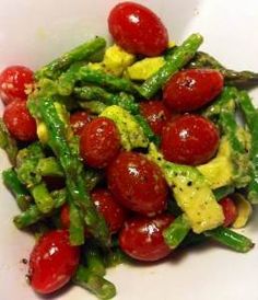 a white bowl filled with asparagus and cherry tomatoes