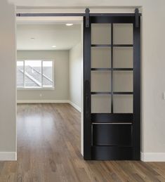 an empty room with a sliding door and hard wood flooring