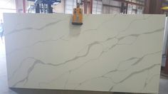 a large white marble slab in a warehouse with tools on it's back wall