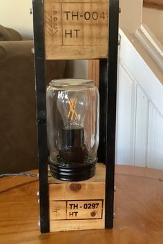 a wooden box with a light bulb on it sitting on top of a table next to stairs