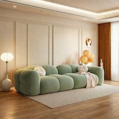 a living room with wooden floors and white walls, green couches on the floor