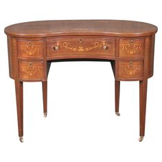 a wooden desk with two drawers on one side and an ornate design on the other