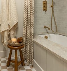 a bathroom with a checkered floor and white tile on the walls, along with a bathtub