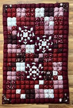 a red and white quilt on a wooden floor