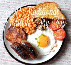 an english breakfast with bacon, eggs, beans and toast on a plate that says traditional british fry up