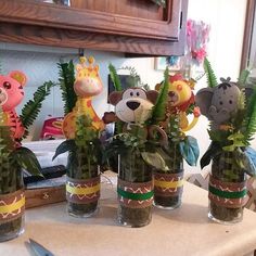 several vases filled with plants and stuffed animals