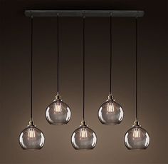 five clear glass globe lights hanging from a ceiling