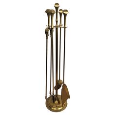 an antique brass plated metal fireplace tool holder with five candles and four spoons