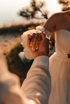 the bride and groom hold hands as they walk together