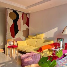 a living room filled with lots of furniture and colorful rugs on the wall behind it