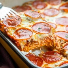 a close up of a slice of pizza on a pan with a fork in it